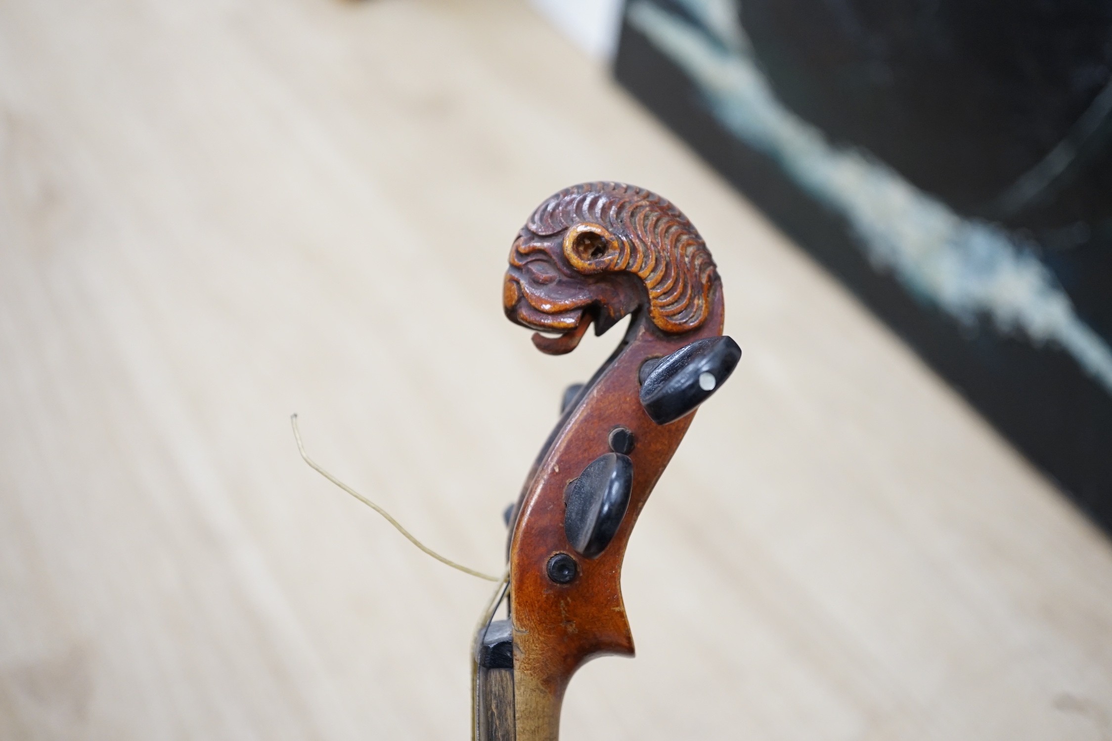 A late 19th century lion head violin and case
